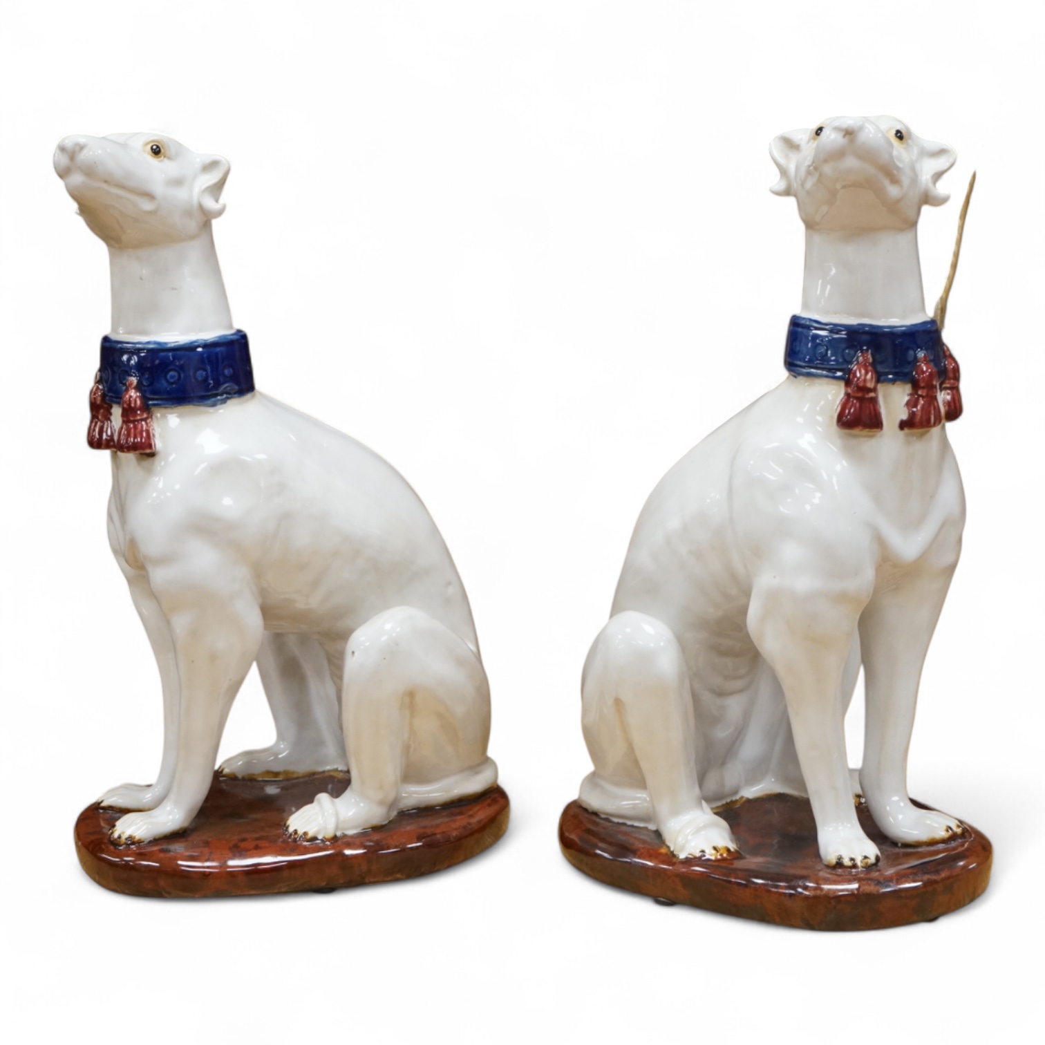 A pair tin glaze models of seated dogs, possibly Greyhounds. 36cm high.